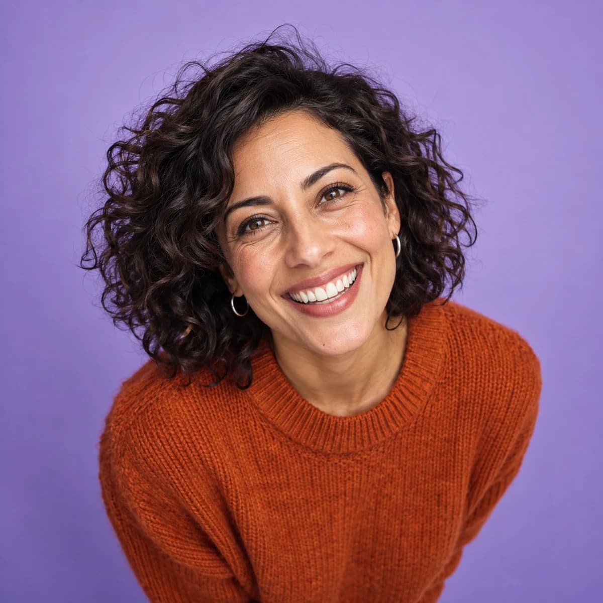 Original editorial portrait of a smiling woman against a lavender background