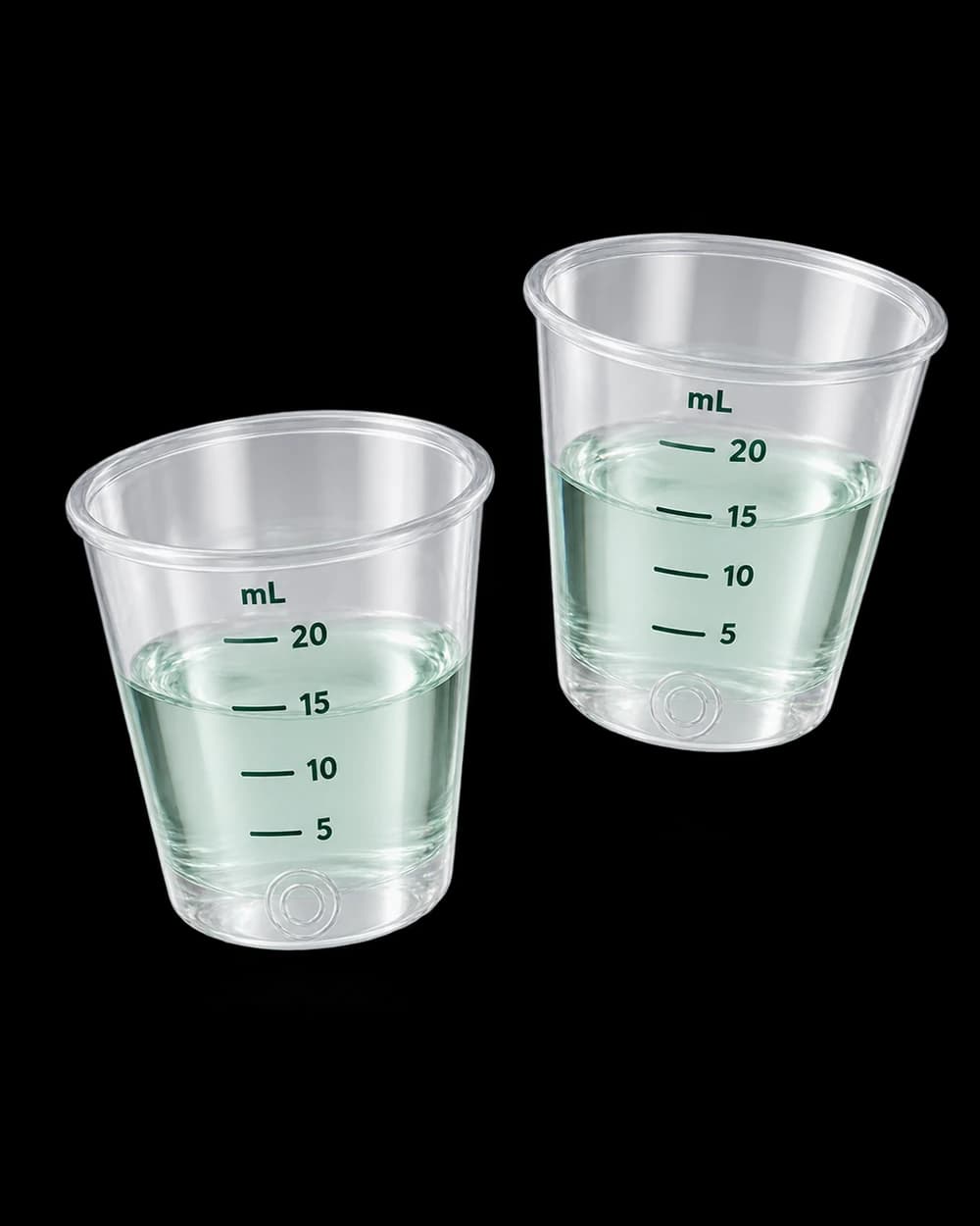 Two clear measuring cups with mL markings and pale mint rinse