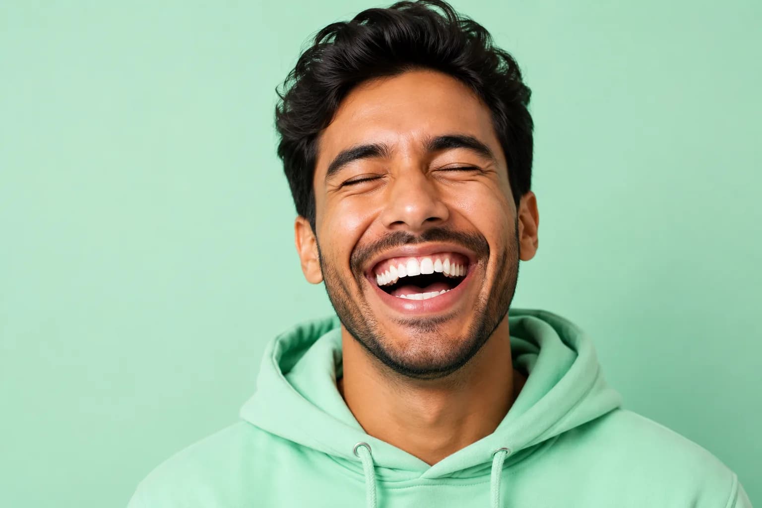 A bright smile in a green hoodie