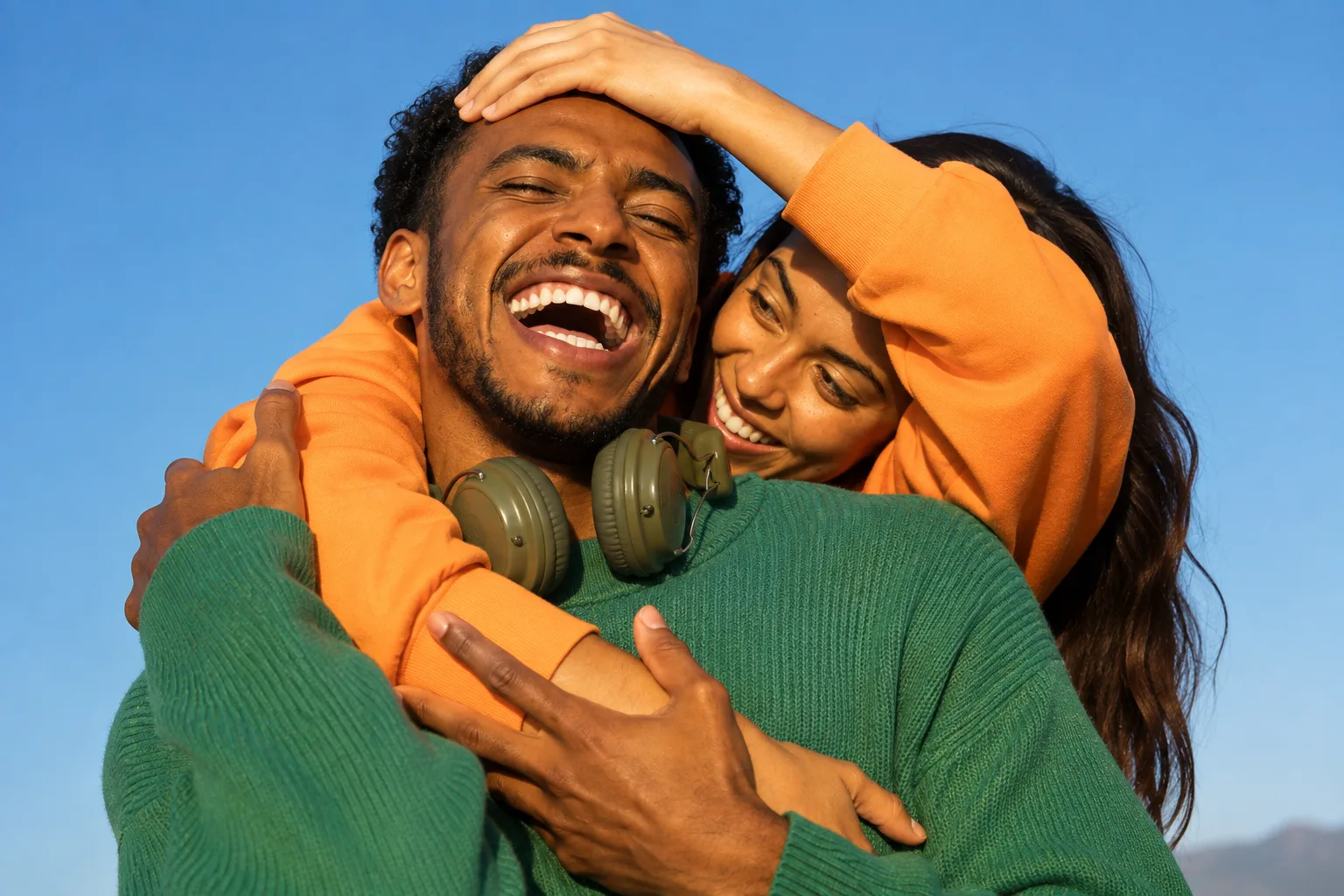 A couple laughing, arms around each other