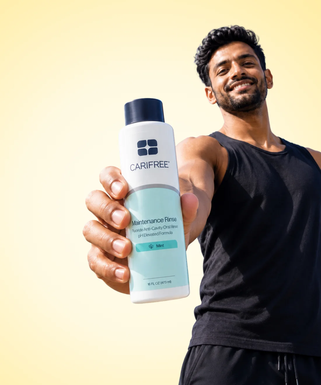 A OneOral member holding out a bottle of rinse