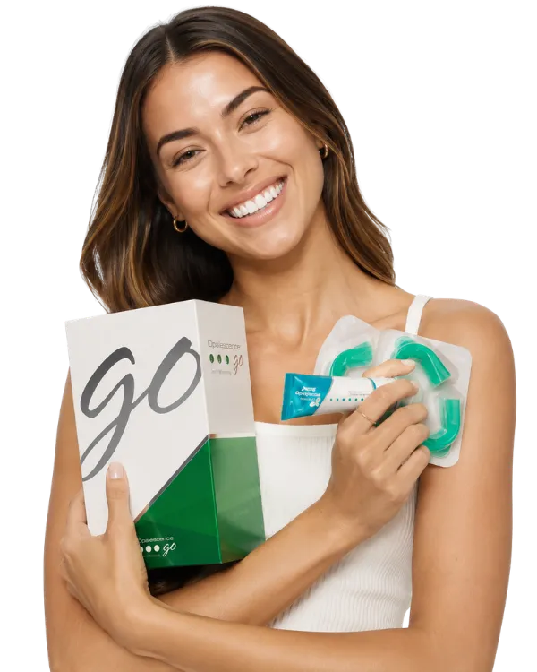 A smiling model holding the OneOral whitening kit